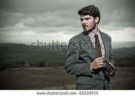 Vintage Photographer holding  a folding camera in his hands