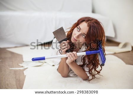 Young beautiful woman doing repairs in the house with tools. The premises, work, update.