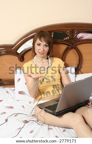 beautiful girl blonde on bed in underwear communicates by means of computer on  Internet morning