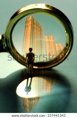 The magnifying glass and the buildings, the real estate business concept
