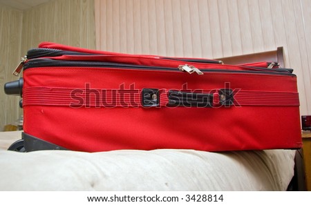 Wide angle shot of suit case on bed