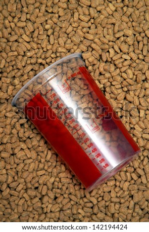 dry brown  pets food with measured glass