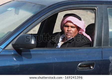EGYPT - FEBRUARY 2: Arab man with red keffiyah driving his car on February 2, 2011 in Dahab, Egypt. Red and white keffiyahs is the pattern used by the majority of the Arab world.