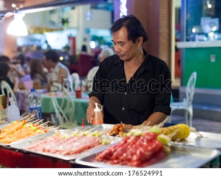 BANGKOK, THAILAND - JANUARY 9, 2012: Man prepares traditional Thai food on Khao San Road food stall. Everyday thousands of tourists and locals buys food on these stalls.