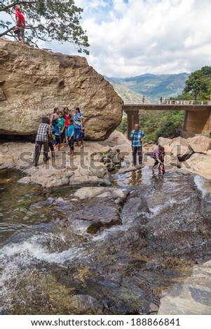 RAVANA FALLS, SRI LANKA - MARCH 2, 2014: Local tourists at Ravana falls, popular sightseeing attraction and one of the widest falls in the country.