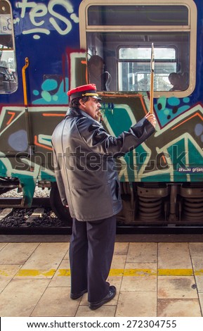 ZAGREB, CROATIA - 17 MARCH 2015: Controler signaling to the train driver with his wistle and sign to mark the departure on platform number 1 in Glavni kolodvor (main train station).