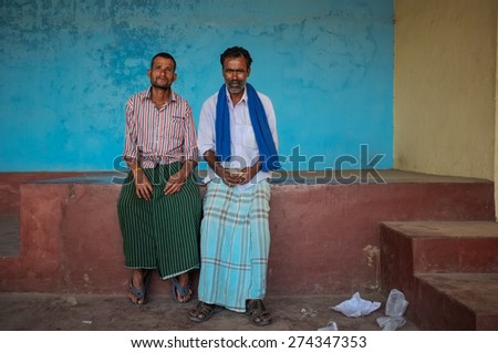 KAMALAPURAM, INDIA - 02 FEBRUARY 2015: Indian men sitting under a covered space on a market close to Hampi