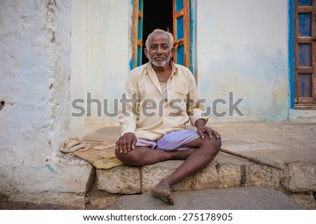 KAMALAPURAM, INDIA - 02 FEBRUARY 2015: Elderly Indian man sitting in front of his home in the old town.