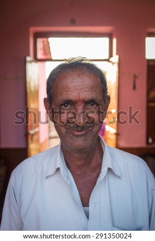GODWAR REGION, INDIA - 12 FEBRUARY 2015: Elderly Indian man in home with door open in background.