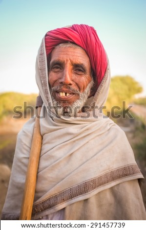 GODWAR REGION, INDIA - 14 FEBRUARY 2015: Elderly Rabari tribesman stands with axe on sholder. Rabari or Rewari are an Indian community in the state of Gujarat.