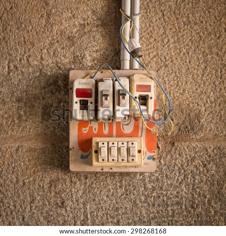 HAMPI, INDIA - 28 JANUARY 2015: Small safety fuse with switches on stone wall.
