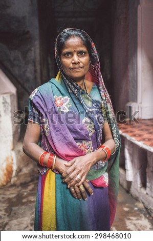 VARANASI, INDIA - 20 FEBRUARY 2015: Indian woman in colorful sari with bindi stands in street. Post-processed with grain, texture and colour effect.