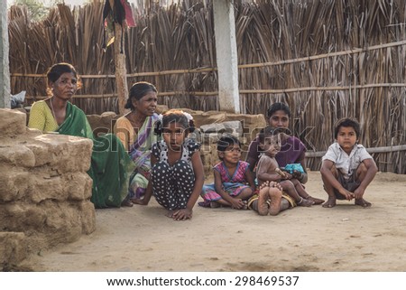 HAMPI, INDIA - 31 JANUARY 2015: indian family sitting on clean soil ground in evening shade. Post-processed with grain, texture and colour effect.