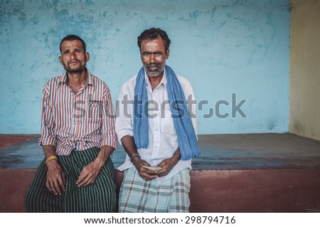 KAMALAPURAM, INDIA - 02 FABRUARY 2015: Indian men sit under a covered space on a market close to Hampi. Post-processed with grain, texture and colour effect.