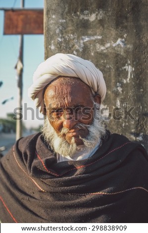 GODWAR REGION, INDIA - 14 FEBRUARY 2015: Elderly tribesman with white turban and dark blanket. Post-processed with grain, texture and colour effect.