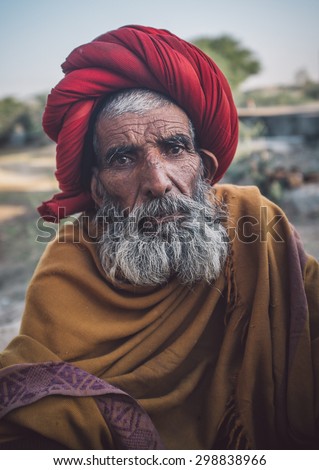 GODWAR REGION, INDIA - 14 FEBRUARY 2015: Elderly Rabari tribesman with red turban and blanket around the shoulders. Post-processed with grain, texture and colour effect..