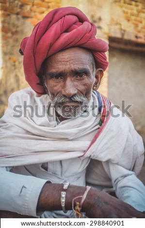 GODWAR REGION, INDIA - 14 FEBRUARY 2015: Elderly Rabari tribesman with red turban and blanket around the shoulders. Post-processed with grain, texture and colour effect.