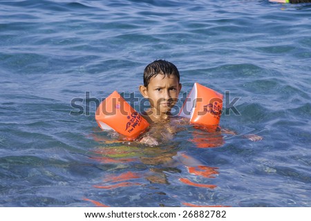 ANTALYA, TURKEY - JULY 31 : Young Turkish boy floats with swimming aid in Antalya, Turkey on July 31, 2007. Olympos is located 90 km southwest of Antalya city near Kemer.