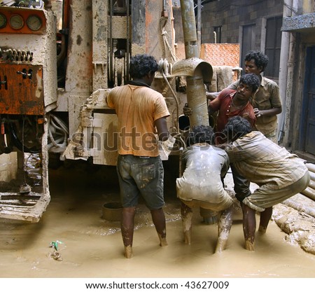 DEHLI - SEPT 19. Hard working indians boring a hole to access water on September 19, 2007 in Dehli, India. Limited water resources in growing capital cities will become increasingly problematic.