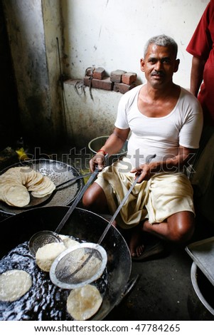DELHI - FEBRUARY 26: Man cooking chapatis in oil to make Puri on February 26, 2008 in Dehli, India. Chapatis are the staple diet of all Indians.