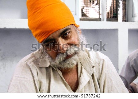 DELHI - SEPTEMBER 22:  Old bearded Sikh with orange turban at Sis Ganj Gurdwara temple  on September 22, 2007 in Delhi, India. Worldwide there are about 25 million Sikhs.