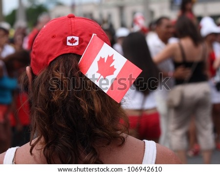 OTTAWA, CANADA - JULY 1: A woman watching others dance in the street on Canada Day, July 1, 2012 in Ottawa, Ontario. Canada Day is a national holiday, and is celebrated each July 1st.