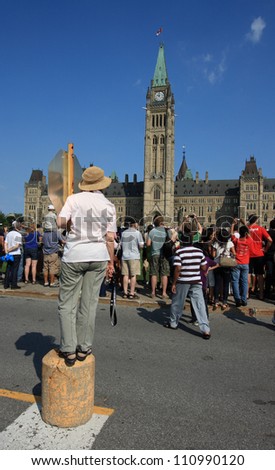 OTTAWA, CANADA - AUGUST 4: People trying to get a view of the Ceremonial Guards on Parliament Hill during a Changing of the Guard Ceremony on August 4, 2012 in Ottawa, Ontario.