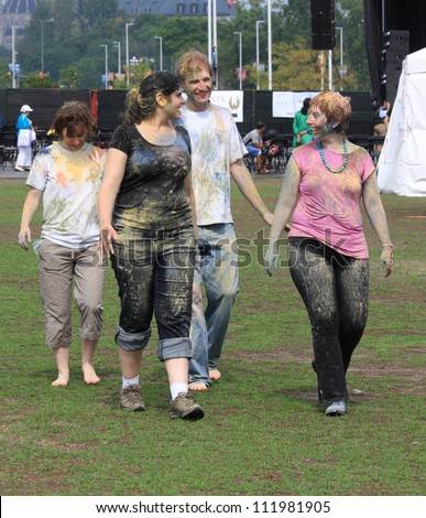 OTTAWA, CANADA-AUGUST 11: People walking together after playing holi at the inaugural Festival of India on August 11, 2012 in Ottawa, Ontario. Holi is a tag-like game that uses colored powders.