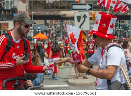 OTTAWA, CANADA - JULY 1: A man buying flags from a street vendor during Canada Day on July 1, 2013 in downtown Ottawa, Ontario.