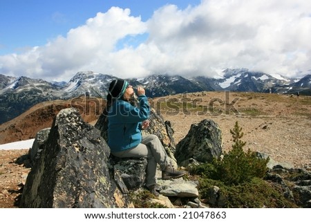 A woman blowing soap bubbles on Flute Summit. Garibaldi Provincial Park, British Columbia, Canada.