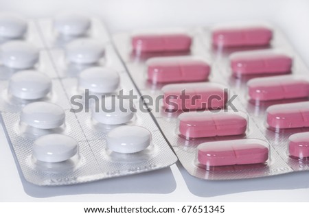 Blister pack of white and pink pills isolated on white background