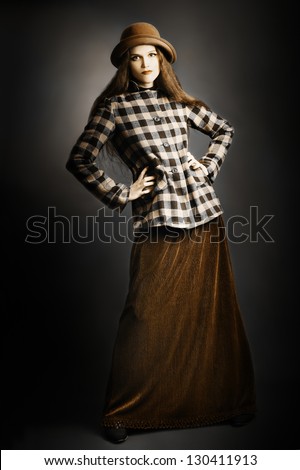 Retro woman in vintage fashion clothes. Model in long skirt, hat and checkered jacket