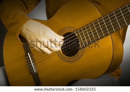 Acoustic guitar player guitarist hand playing. Musical instrument with hand playing closeup details