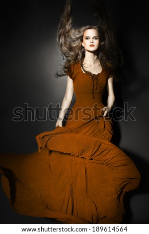 Fashion model in long dress. Elegant woman in maxi flying dress