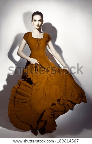 Fashion model in long dress. Elegant woman in maxi flying dress