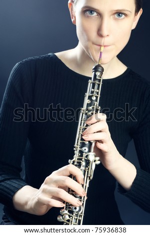 Oboe musical instrument playing. Young oboist musician woman playing classical oboe.