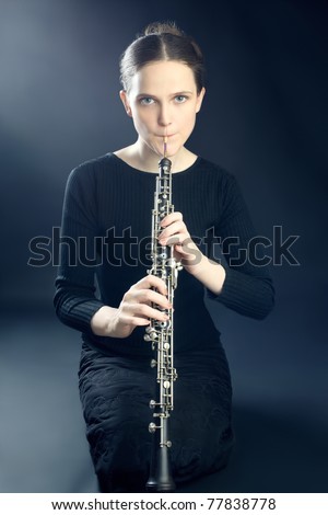 Young musician woman playing oboe. Oboist musical instrument play. It\'s instrument of classical symphony orchestra.