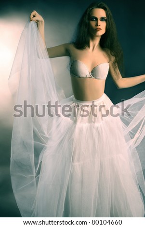 Fashion portrait of beautiful elegant woman in white wide long flared skirt and bra