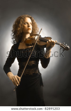 Violin playing violinist musician symphony. Artistic portrait of beautiful woman fiddler music performer