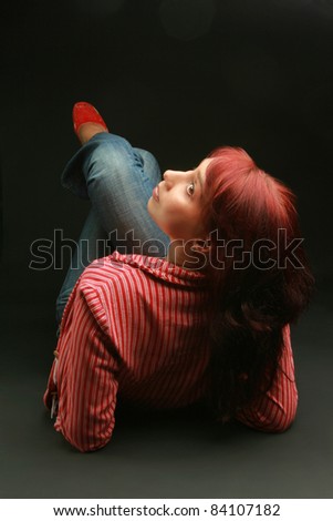 Modern lying looking woman back with red hair on black background