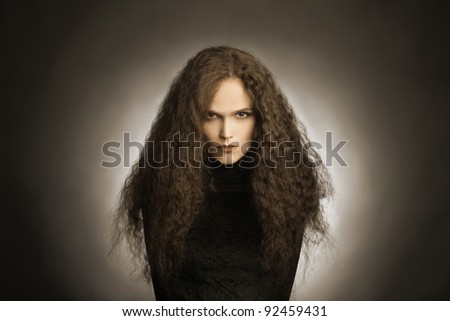 Portrait of beautiful woman with thick long curly hair.