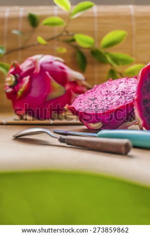 Dragon fruits and dragon fruits cut, knife and spoon. Lots of copy space