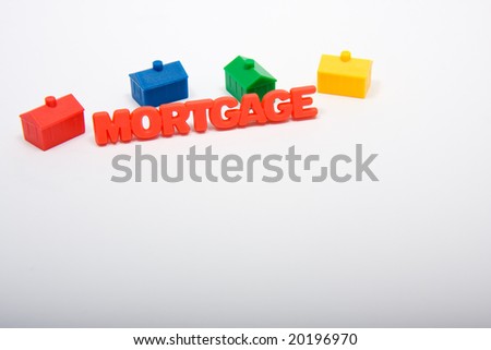 Toy houses surrounding the word mortgage, with copy space beneath