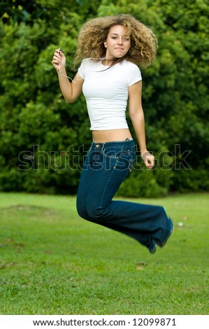 A beautiful young girl jumping to music outside