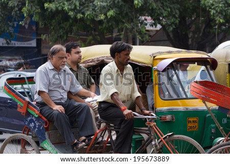 DELHI, INDIA-AUGUST 29, 2011: Unidentified Indian trishaw driver  in Delhi, India. Bicycle rickshaw on the street of Delhi.