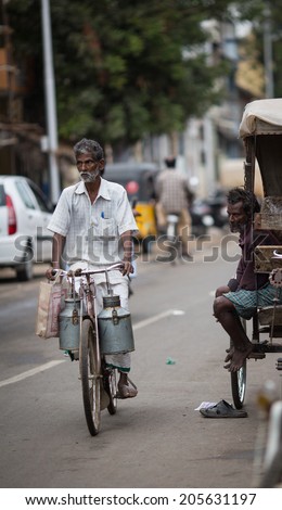 TRICHY, INDIA-FEBRUARY 14: Street of Indian city 14, 2013 in Trichy, India. Old man with a bike on the street of indian town