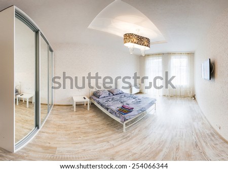 Large spacious bedroom with double bed. Panorama of the interior of a hotel room. Interior light room in a modern style.