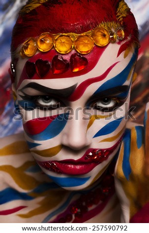 Portrait of a woman with a painted face. Creative makeup and bright style.