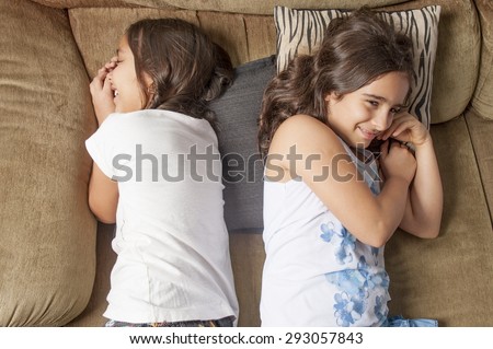 Two cute young girls in the sofa .