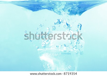 Ice cube fall in the water - refreshing splash .